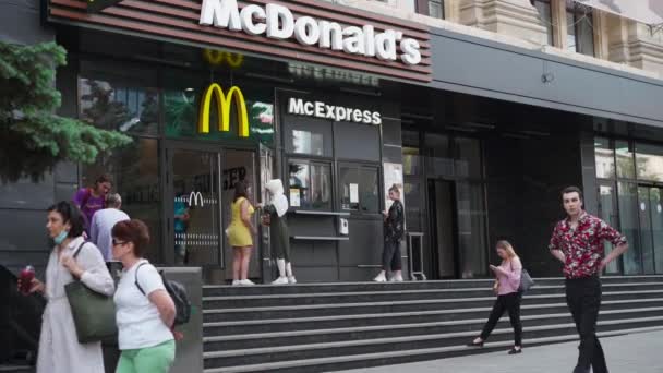 Ucrânia, Kharkov Maio 2021 McDonalds entrada de restaurante na cidade central Sumskaya rua Pessoas caminhando dia de verão — Vídeo de Stock
