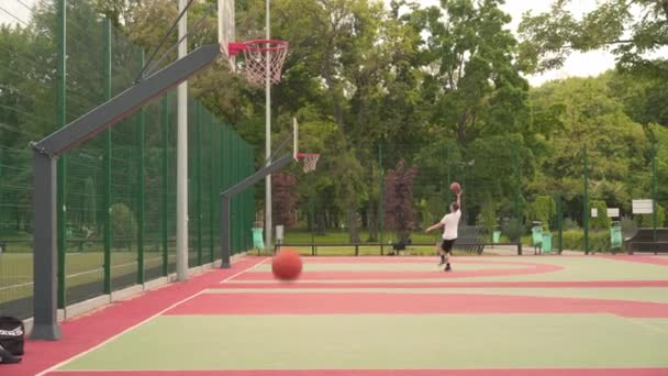 Charkov, Ukrajina Květen 2021 Mladí aktivní lidé hrají streetball na krásném venkovním sportovišti. — Stock video