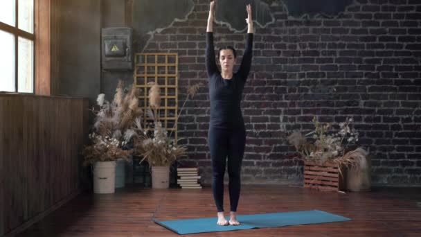 Femme pratiquant le yoga en classe intérieure. Exercice d'étirement lumière du jour. — Video