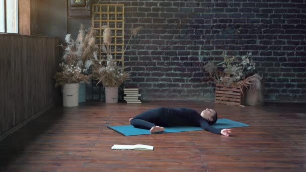Femme pratiquant le yoga en classe intérieure. Exercice d'étirement lumière du jour. — Video