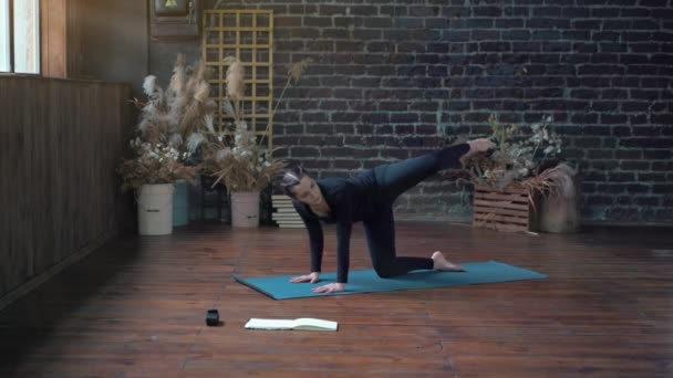 Femme pratiquant le yoga en classe intérieure. Exercice d'étirement lumière du jour. — Video