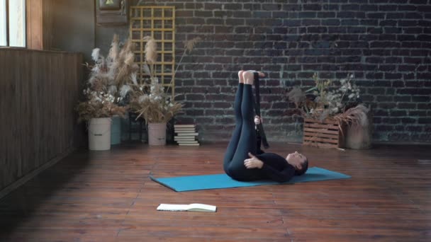 Femme pratiquant le yoga en classe intérieure. Exercice d'étirement lumière du jour. — Video