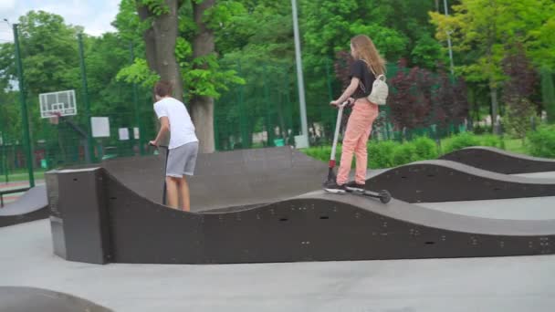 Kharkov, Ukrajna május 2021 Fiatalok görkorcsolyázás gördeszkák és robogók Aktív szabadidő a gördeszka parkban. Egészséges életmód — Stock videók