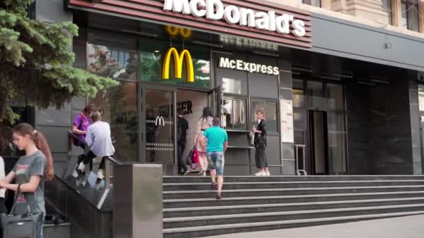 Ucrânia, Kharkov Maio 2021 McDonalds entrada de restaurante na cidade central Sumskaya rua Pessoas caminhando dia de verão — Vídeo de Stock
