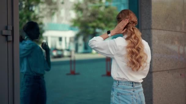 Woman Looking Reflection Building Window Fixing Her Hair — стоковое видео