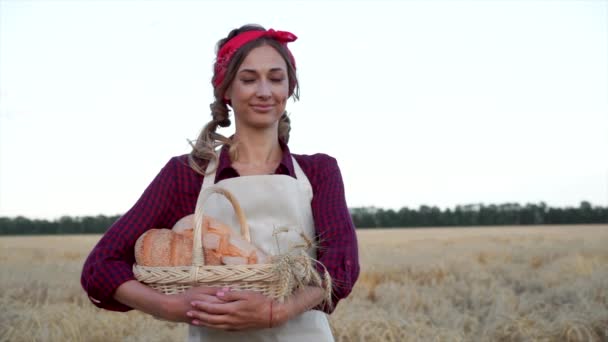 Női mezőgazdasági termelő álló búza mezőgazdasági területen Nő pék gazdaság fonott kosár kenyér termék — Stock videók
