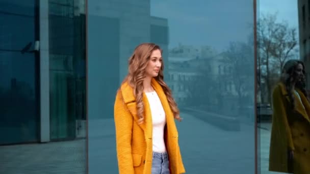 Donna d'affari vestito giallo cappotto camminare all'aperto corporativo edificio sfondo — Video Stock