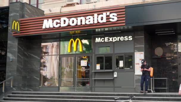 Ucrânia, Kharkov Maio 2021 McDonalds entrada de restaurante na cidade central Sumskaya rua Pessoas caminhando dia de verão — Vídeo de Stock