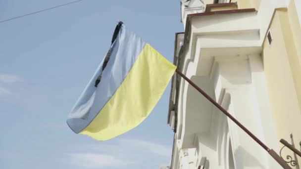 Piangendo bandiera ucraina sul vento con il nastro nero Bandiera gialla blu su costruzione dopo tragedia — Video Stock