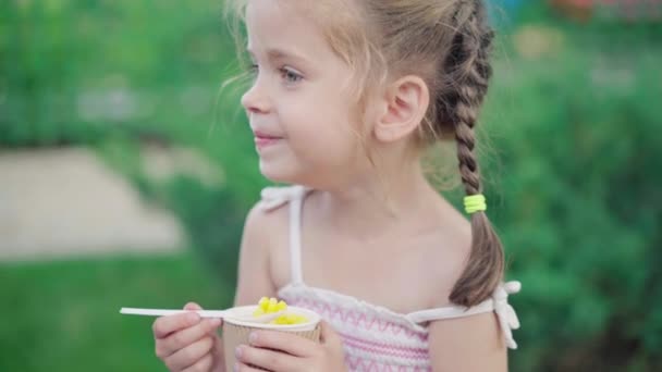 Kleines Mädchen essen Mais Papier Glas Sitzbank Sommer Park — Stockvideo