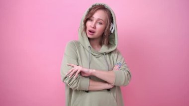 Mutlu dişler gülümser kadın pembe arka planda müzik kulaklıkları dinler.