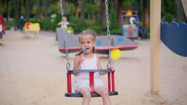 Kleine Mädchen sitzen Schaukel Spielplatz Summer Day Park — Stockvideo