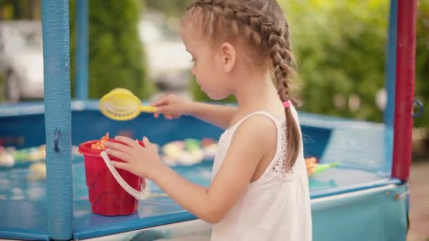 Criança Fisher Pegando peixes de brinquedo de plástico no parque de diversões da piscina Dia de Verão — Vídeo de Stock