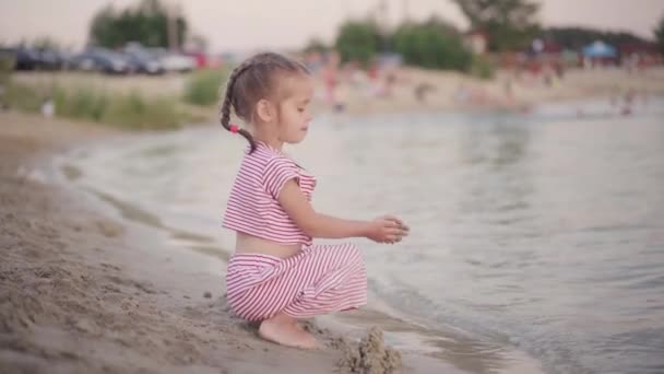 Bambino che gioca vicino all'acqua Costruzione di sabbia Castello sulla spiaggia di mare Orario serale estivo — Video Stock