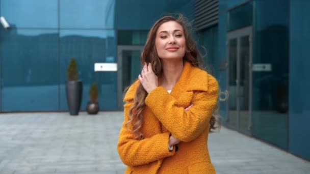 Mujer de negocios vestido abrigo amarillo de pie al aire libre corporativo edificio de fondo — Vídeos de Stock