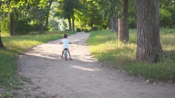 Детская езда Баланс Велосипед Страна Road Park задний вид Солнечный летний день — стоковое видео
