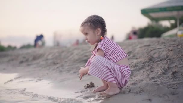 Kind spielt in der Nähe des Wassers Sandburg am Strand Sommer Abend — Stockvideo