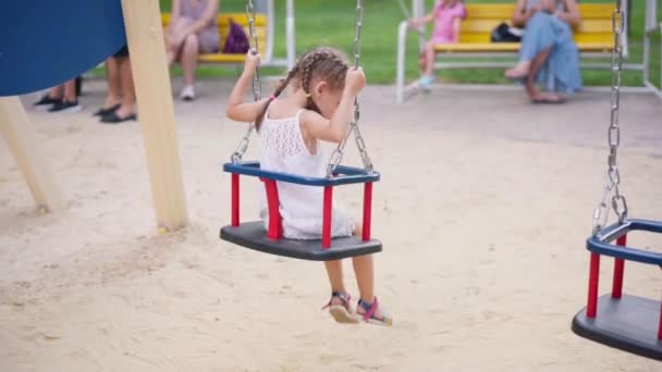 Mała dziewczynka siedzi Huśtawka plac zabaw Summer Day Park — Wideo stockowe