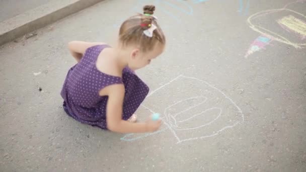 Niño dibujo tiza asfalto camino verano día — Vídeo de stock