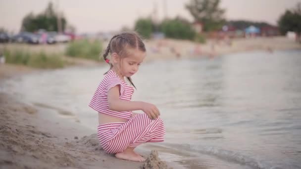 Kind spielt in der Nähe des Wassers Sandburg am Strand Sommer Abend — Stockvideo