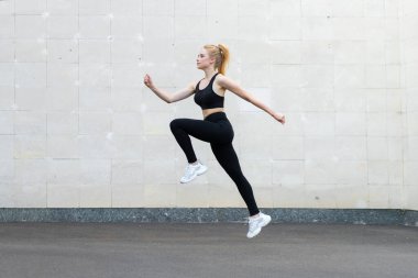 Spor ve Spor Konsepti Genç Kafkas Kadın Atletizm Yüksek Kapıdan Atlayan Gri Kuyruk Duvarı Spor Atlama Egzersizleri Sağlıklı Yaşam Tarzı Motivasyonu