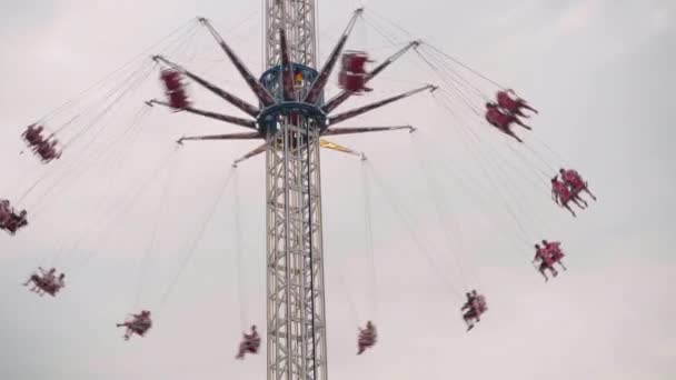 フライングスイングカルーセル遊園地に乗る人々は遊園地で高鎖カルーセルをスイングするときに楽しみを持っています. — ストック動画