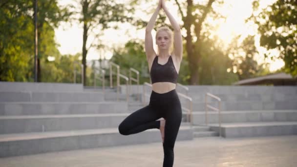 Фітнес жінка практика йога вправи на мат на відкритому повітрі місто вулиця сонячне світло фон — стокове відео