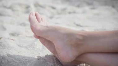 Kadın bacaklarındaki hallux valgus plaj kumuna yakın. Ayak eklem deformasyonu. İnsan vücudunda sağlık ve ilaç sorunu