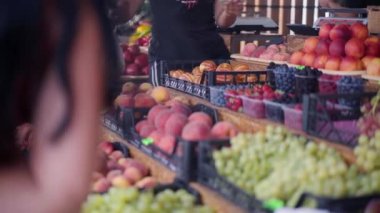 İnsanlar meyveyi açık hava pazarına koyuyorlar. Satıcıya çok para veriyorlar ve limon meyveli plastik torba tutuyorlar. 