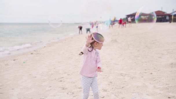 Mutter mit kleinem Kind bläst Seifenblasen am Meer Strand Reisen mit einem Kind Familie Sommerurlaub — Stockvideo