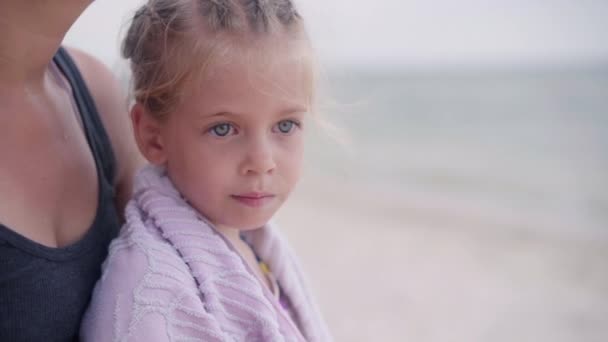 Madre abrazo calienta pequeña hija limpia toalla playa al aire libre día soleado de cerca — Vídeo de stock