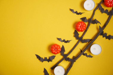 Cadılar Bayramı arka planı, turuncu dekoratif plastik balkabağı siyah yarasa kuru dal sarı karton Şükran Günü tebrik kartı deseni