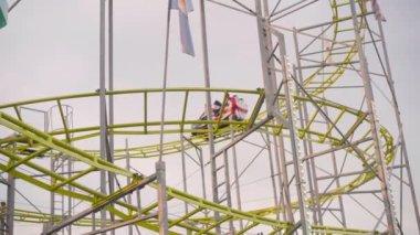 Lunaparkta çalışarak lunaparkta lunapark hız trenine binmek. Lunaparkta aşırı cazibe değişimi yaşanıyor. Düşük açı görünümü.