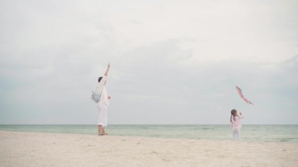Madre con la piccola figlia che gioca aquilone sulla spiaggia del mare Felice famiglia caucasica con un bambino divertirsi in vacanza estiva a Sea Shore — Video Stock