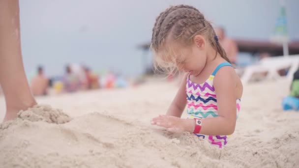 Niedliche kaukasische Mädchen in Sand am Strand begraben — Stockvideo