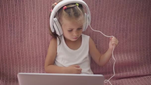 Little Girl Sitting Sofa in Headphones Listen music Use Laptop Have Fun Home Interior Caucasian Female Child Use Technology Modern Children Happy Childhood — Stock Video