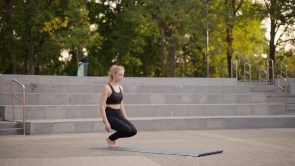 Γυμναστική Γυναίκα Πρακτική Γιόγκα Ασκήσεις Στο Ματ Υπαίθριο City Street Sunlight Ιστορικό — Αρχείο Βίντεο