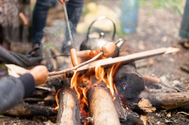 Çaydanlık Sauasge, doğa pikniğinde ızgara kamp ateşi, orman yürüyüşü hazırlıyor.