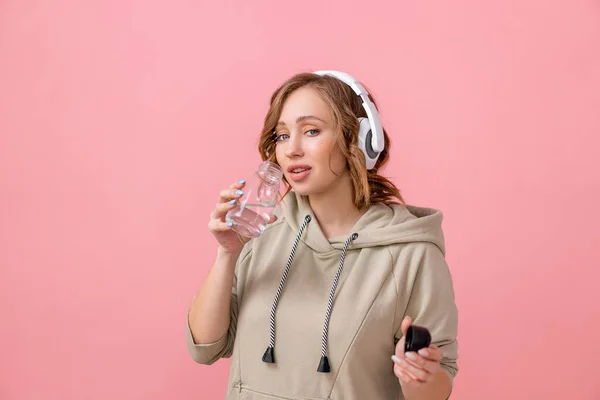 Woman Headphones Dressed Oversize Hoodie Drink Water Glass Bottle Pink — Stock Photo, Image