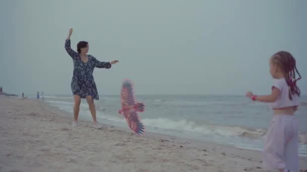 Matka z małą córeczką bawiącą się latawcem na plaży morskiej Szczęśliwa rodzina kaukaska z jednym dzieckiem Baw się dobrze na wakacjach nad morzem — Wideo stockowe