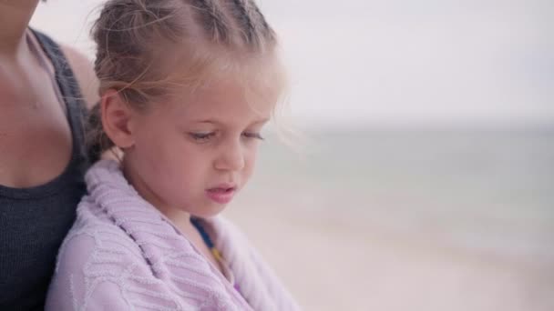 Мама обіймає тепло маленька дочка протирає рушник пляж на відкритому повітрі сонячний день крупним планом — стокове відео