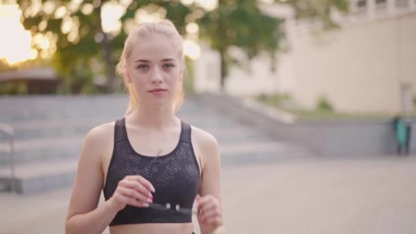 Desporto e Fitness. Jovem caucasiano mulher vestida Sportswear desgaste óculos de pé ao ar livre verão parque luz solar fundo — Vídeo de Stock