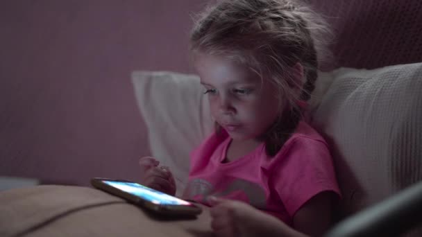 Porträt Nettes kleines Mädchen mit Smartphone. Junge Frau surft im Internet, checkt Social-Media-Video — Stockvideo