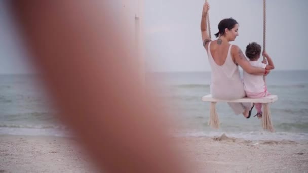 Madre e bambino oscillante sulla spiaggia swing con bella vista mare famiglia con un bambino in vacanza — Video Stock