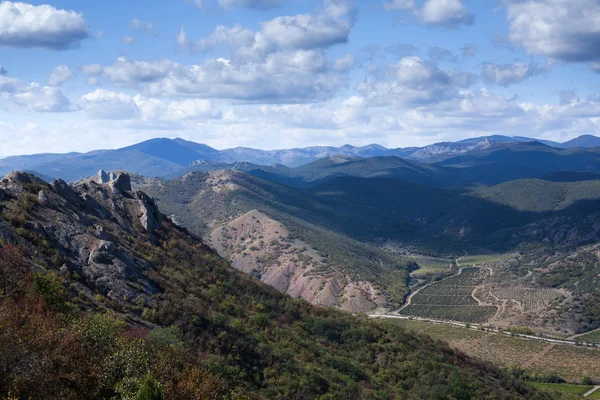 Paesaggio con alberi gialli e verdi contro le montagne e il — Foto Stock