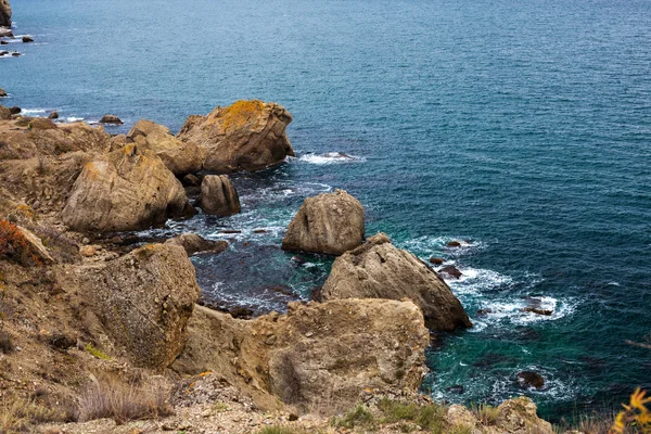 Большая каменная скала над морской водой — стоковое фото
