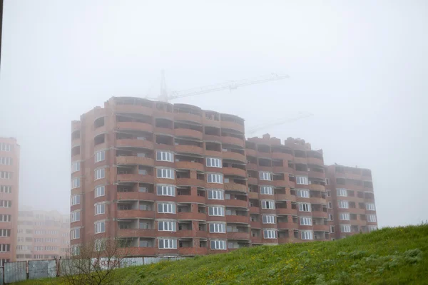Bouw gebouw kranen in de mist — Stockfoto