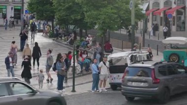 Portekiz, Lizbon 25 Haziran 2025 İnsanlar etkileşimde, araçlar geçerken ve yerel cazibe havayı doldururken Lizbon 'da canlı bir caddede toplanıyor. Portekiz 'in sıcaklığı her an hissedilebilir..