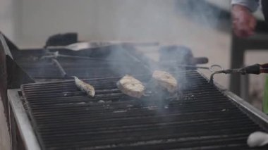 Yetenekli bir aşçının Lizbon, Portekiz sokaklarında ızgarada taze balık pişirmesini izleyin. Duman yükseldikçe koku havayı dolduruyor, yerel mutfağın özünü yakalıyor..