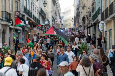 Lizbon, Portekiz 17 Haziran 2025 'te Filistin yürüyüşü sırasında şehir merkezinde toplanan kalabalık bayrak sallıyor ve pankart tutuyordu. Eylemciler amaçlarını savundukları için atmosfer çok canlı.